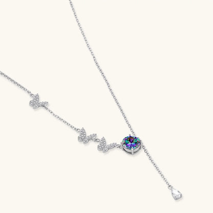 Sterling silver jewelry set with rainbow moissanite stones in clover and butterfly designs on cream background