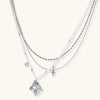 Multi-strand layered necklace set with silver chains, white pearls, star charm, heart pendant, and ornate decorative piece