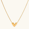 Dainty 18K gold-plated sterling silver necklace with small heart pendant on delicate chain against cream background.