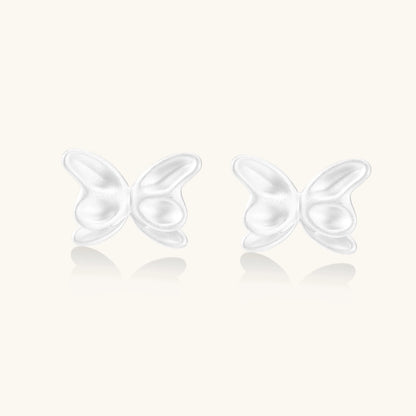 Pair of translucent butterfly-shaped stud earrings with frosted finish and dimensional wing details on white background