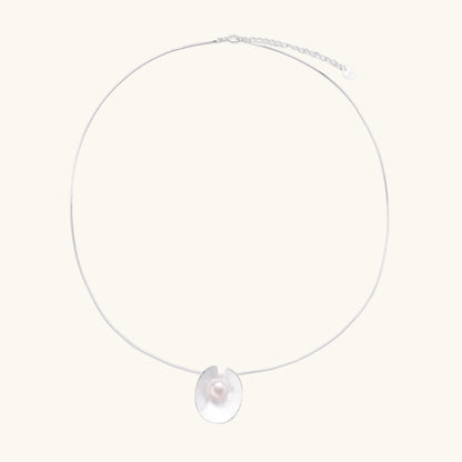 Sterling silver disc necklace with textured finish and centered freshwater pearl on delicate chain