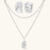Modern textured hoop earrings and layered chain necklace with liquid metal pendant in silver and gold finishes.