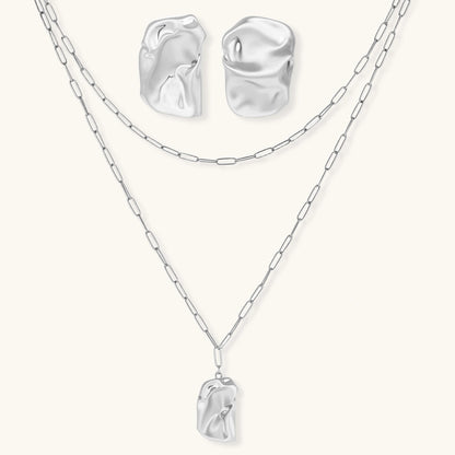 Modern textured hoop earrings and layered chain necklace with liquid metal pendant in silver and gold finishes.