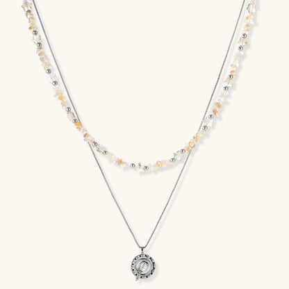 Complete jewelry set featuring citrine stone chips, silver beads, and cosmic circle pendants on cream background.