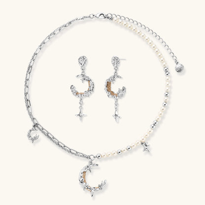 Mixed-metal jewelry set featuring layered necklaces with crescent moon pendant and pearl beads, plus matching star-drop earrings.