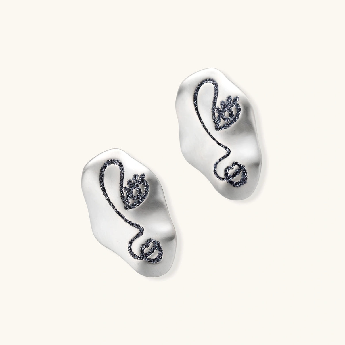 Artistic ear-shaped earrings with minimalist face line art on clear eco-zinc alloy base with sterling silver posts.