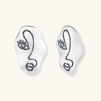 Artistic ear-shaped earrings with minimalist face line art on clear eco-zinc alloy base with sterling silver posts.