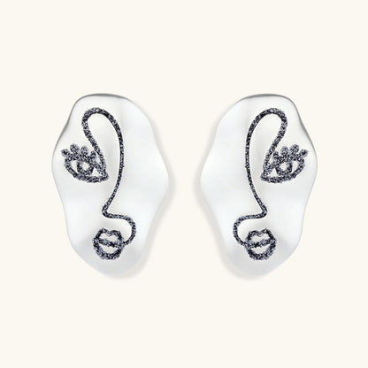 Artistic ear-shaped earrings with minimalist face line art on clear eco-zinc alloy base with sterling silver posts.