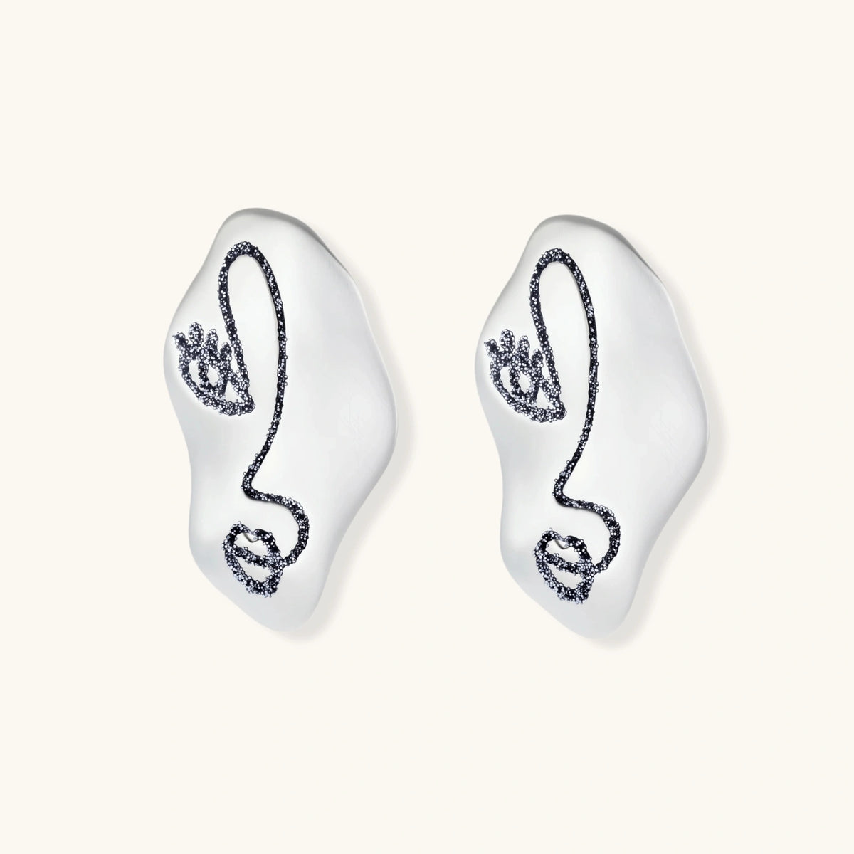 Artistic ear-shaped earrings with minimalist face line art on clear eco-zinc alloy base with sterling silver posts.