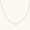 Delicate 14K gold-plated box chain necklace with evenly spaced bar links, shown flat on cream background.
