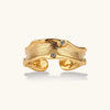 Gold-plated sculptural ring with flowing wave texture and two round zirconia stones in adjustable cuff design