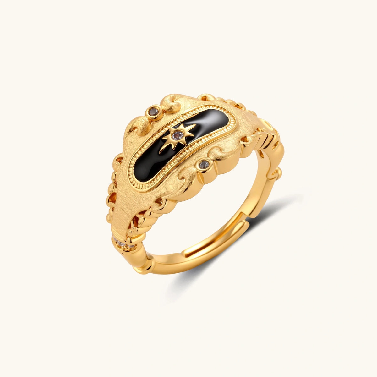 Ornate 18K gold-plated ring with black enamel center featuring star motif and decorative baroque-style edges on white background.