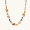 Gold-plated necklace with baroque pearls, purple amethyst stones, and wire-wrapped details on white background.