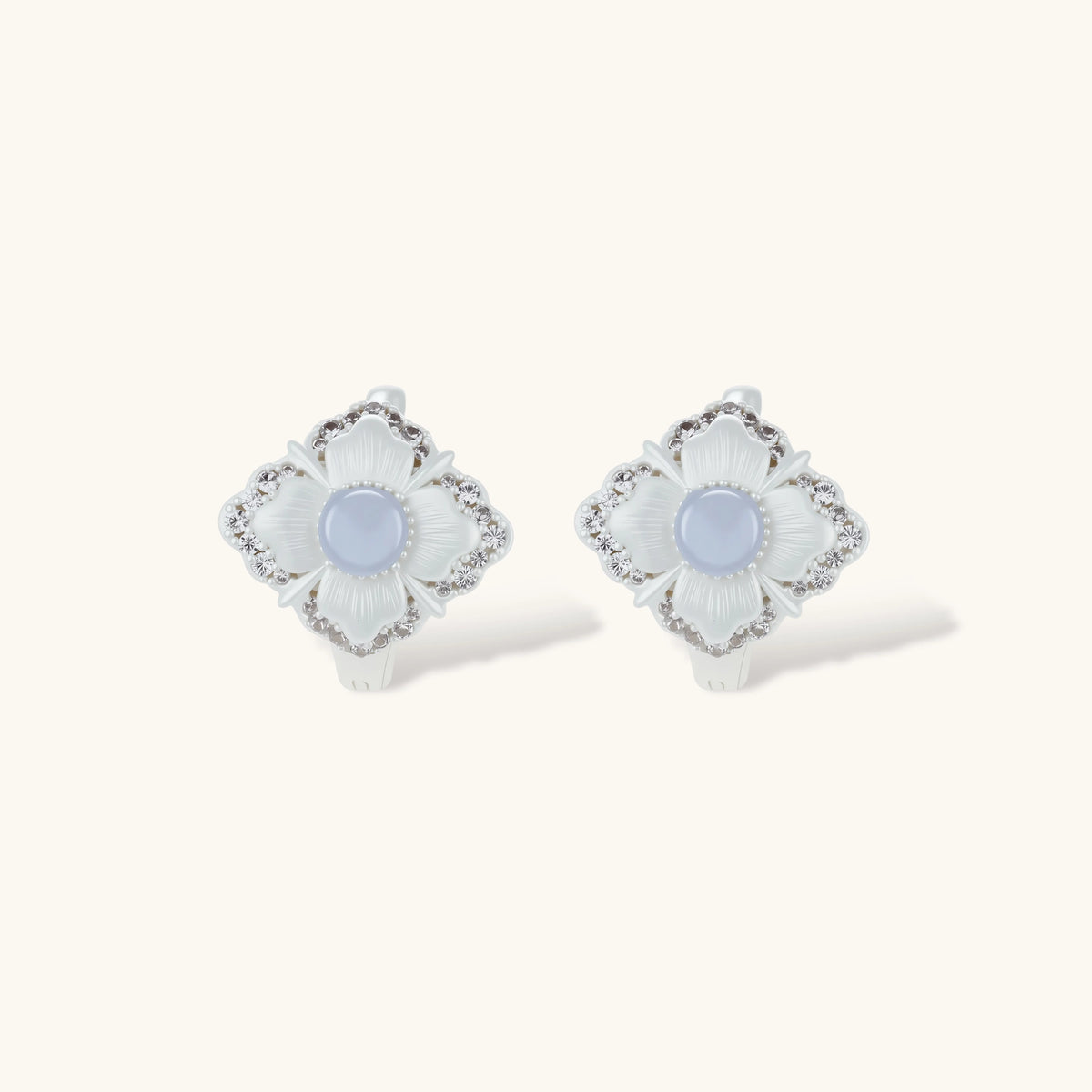 Silver-plated flower earrings with blue zirconia centers, featuring one stud and one huggie hoop in mismatched pair style.