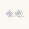 Silver-plated flower earrings with blue zirconia centers, featuring one stud and one huggie hoop in mismatched pair style.