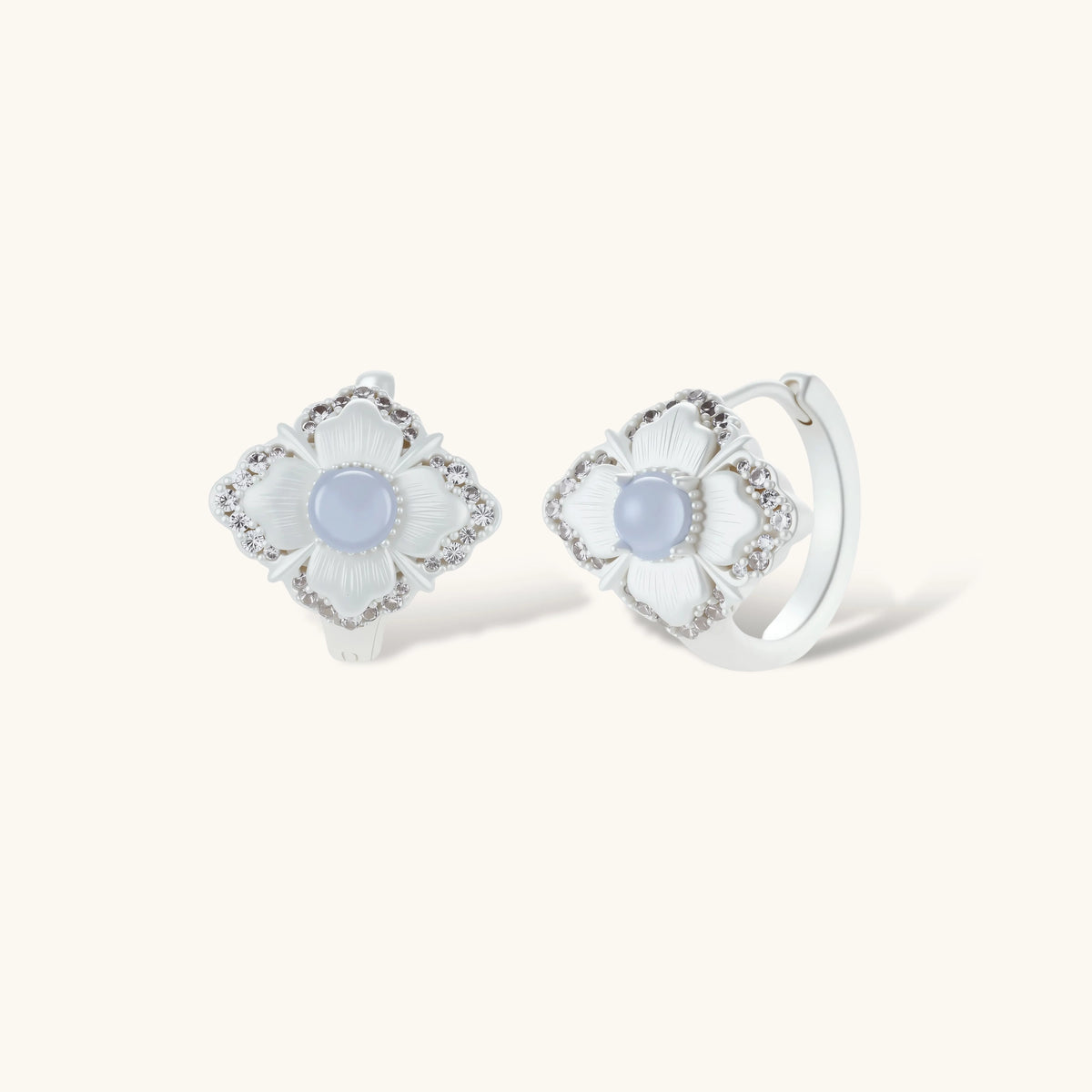 Silver-plated flower earrings with blue zirconia centers, featuring one stud and one huggie hoop in mismatched pair style.